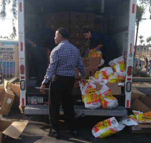 Pastor Gregory Johnson, co-founder of AUHS, unboxing and bagging turkeys to give to needy persons at the annual Acts of Love event.